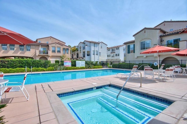 view of swimming pool featuring a community hot tub and a patio