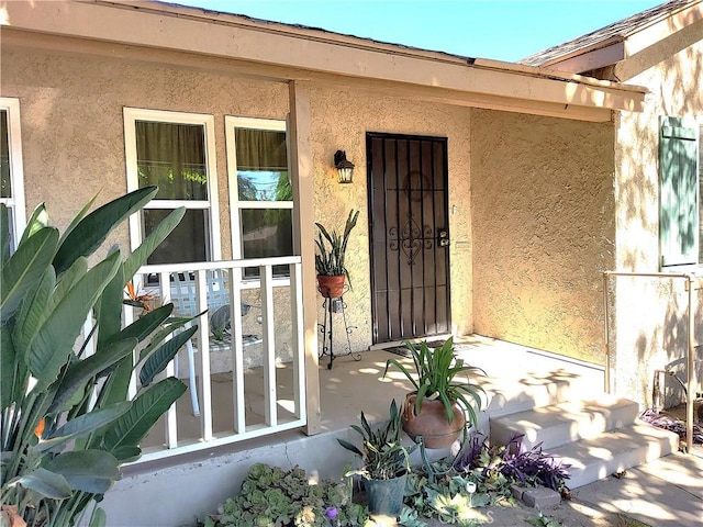 entrance to property featuring stucco siding