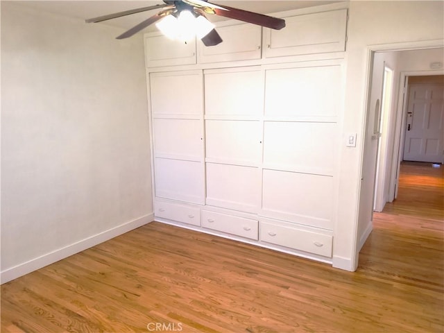 unfurnished bedroom featuring ceiling fan, baseboards, and wood finished floors