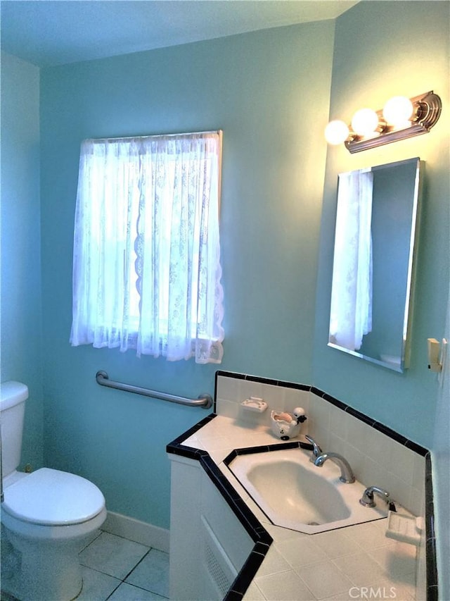 bathroom featuring toilet, baseboards, vanity, and tile patterned floors