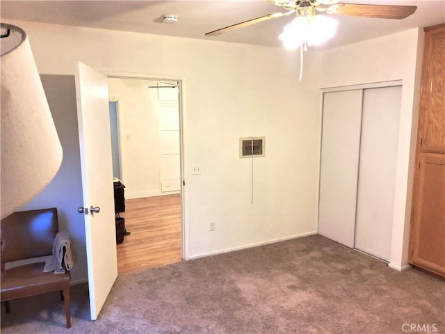 carpeted bedroom featuring a ceiling fan, visible vents, and a closet