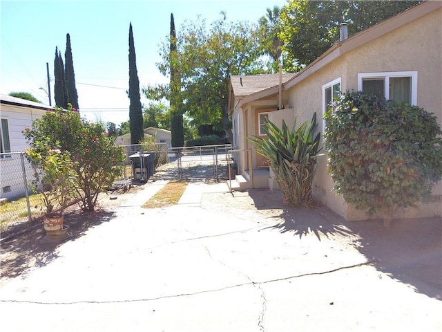 exterior space with a patio area, fence, and stucco siding