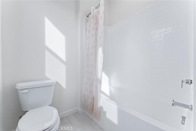 bathroom featuring shower / tub combo and toilet