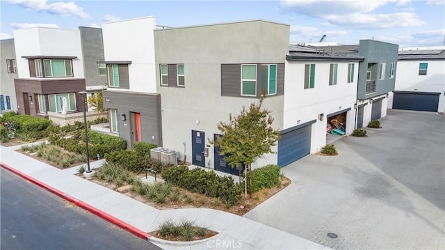 view of front of property featuring a garage and central air condition unit