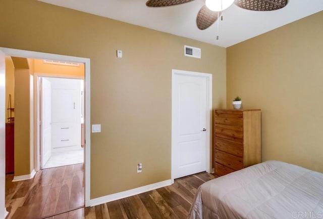 bedroom with ceiling fan, baseboards, wood finished floors, and visible vents