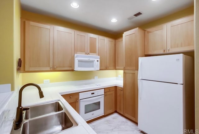 kitchen featuring recessed lighting, light countertops, visible vents, a sink, and white appliances