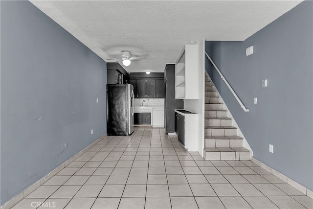 kitchen featuring sink, light tile patterned flooring, a textured ceiling, stainless steel refrigerator, and ceiling fan