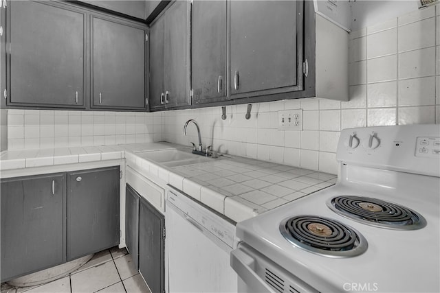 kitchen with decorative backsplash, tile countertops, sink, light tile patterned floors, and white appliances