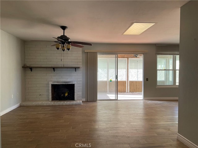 unfurnished living room with ceiling fan, wood-type flooring, and a fireplace