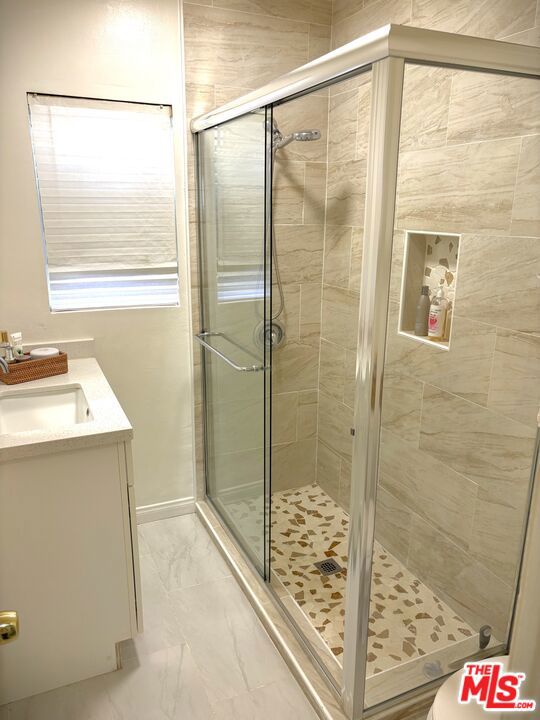 bathroom featuring vanity and an enclosed shower