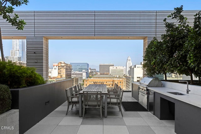 view of patio with area for grilling, an outdoor kitchen, and sink