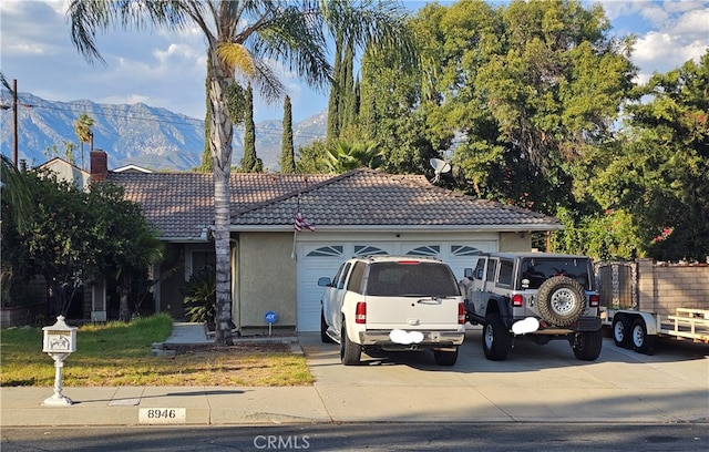 view of front facade featuring a garage and a mountain view