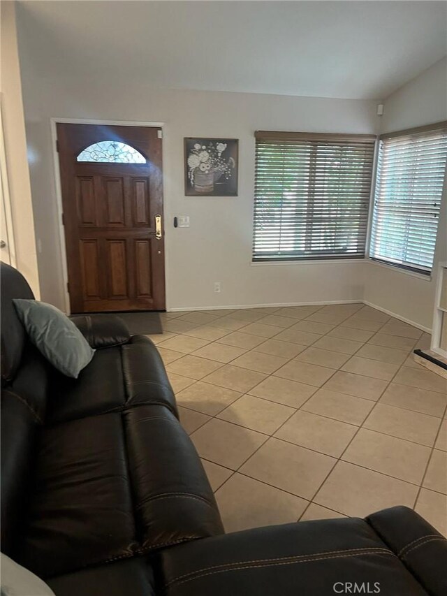 living room with lofted ceiling and light tile patterned floors