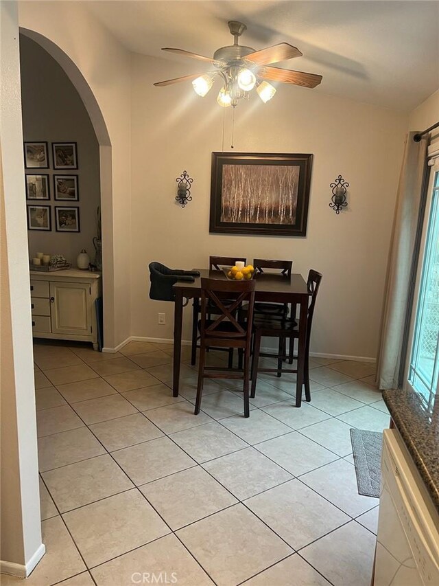 tiled dining room featuring ceiling fan and vaulted ceiling