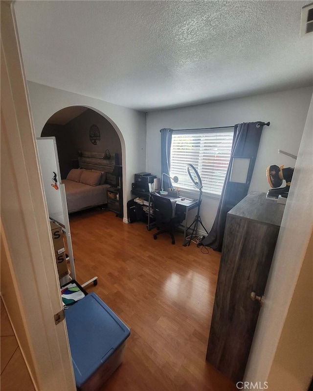 bedroom with a textured ceiling and hardwood / wood-style flooring