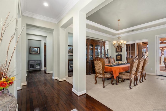 dining space with a chandelier, dark wood-type flooring, and ornamental molding