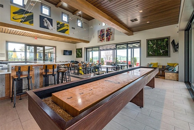 recreation room with wood ceiling, a towering ceiling, beam ceiling, and light tile patterned floors