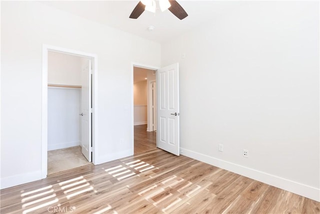 unfurnished bedroom featuring ceiling fan, light hardwood / wood-style floors, and a closet