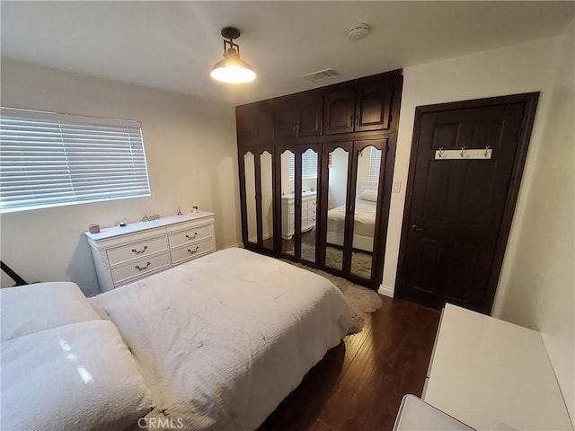 bedroom with dark hardwood / wood-style flooring