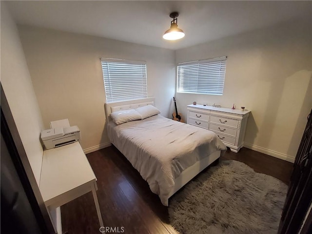 bedroom with dark hardwood / wood-style floors