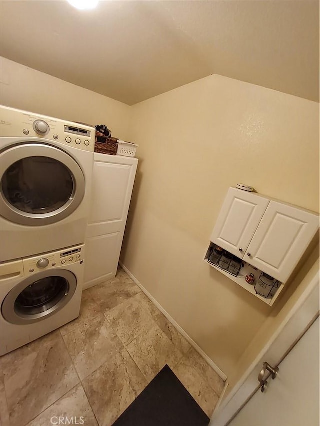 washroom featuring cabinets and stacked washer / drying machine