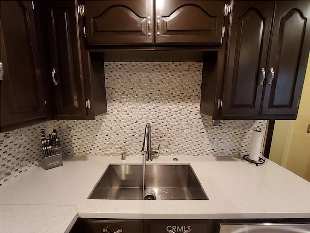 kitchen featuring tasteful backsplash, dark brown cabinets, and sink