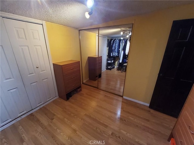 corridor featuring a textured ceiling and light hardwood / wood-style floors