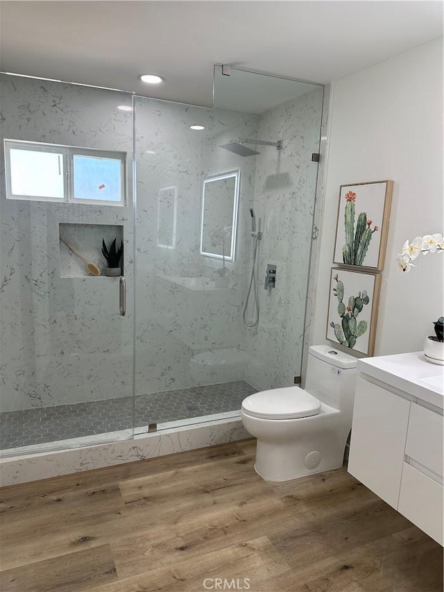 bathroom featuring vanity, hardwood / wood-style flooring, toilet, and walk in shower