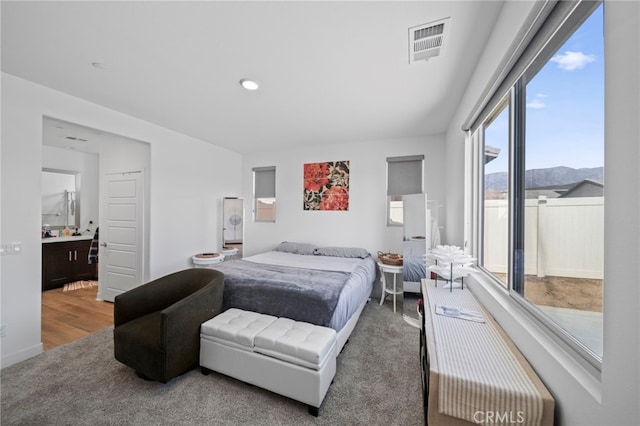 bedroom featuring a mountain view, ensuite bath, and hardwood / wood-style floors