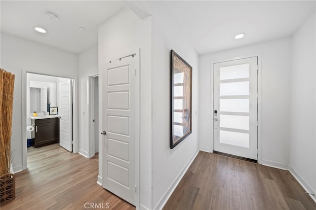 foyer entrance featuring sink and light wood-type flooring