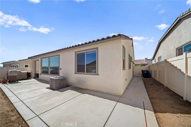 rear view of property featuring a patio area and cooling unit