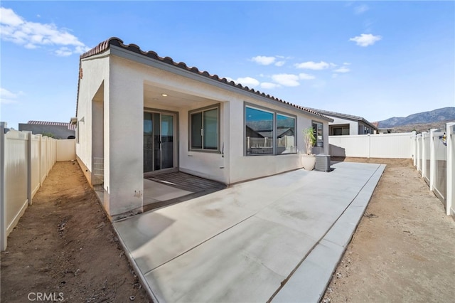 back of house featuring a mountain view and a patio area