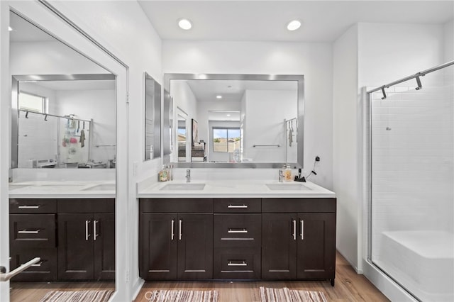 bathroom with vanity, a shower with door, and hardwood / wood-style floors