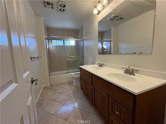 full bathroom featuring vanity, enclosed tub / shower combo, and toilet