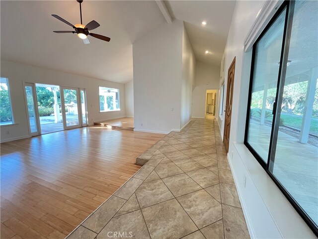 spare room with beam ceiling, high vaulted ceiling, light hardwood / wood-style floors, and ceiling fan