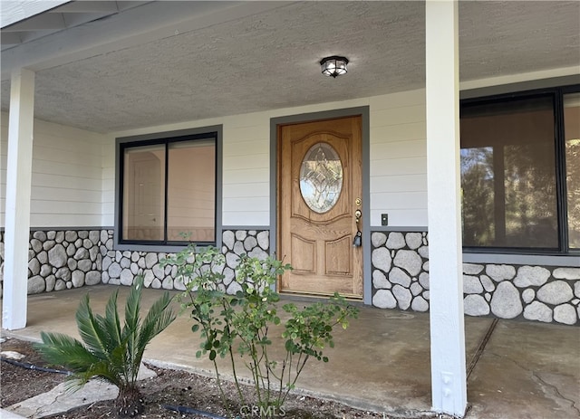 view of exterior entry with a porch