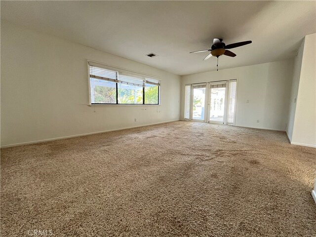 carpeted empty room featuring french doors and ceiling fan