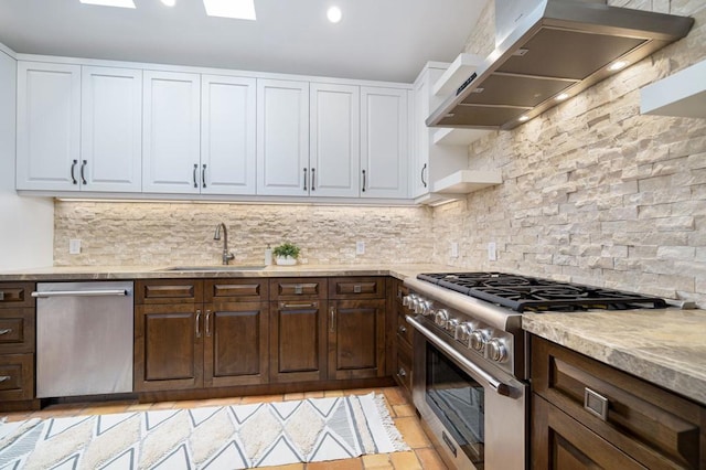 kitchen with backsplash, stainless steel appliances, wall chimney range hood, and white cabinets