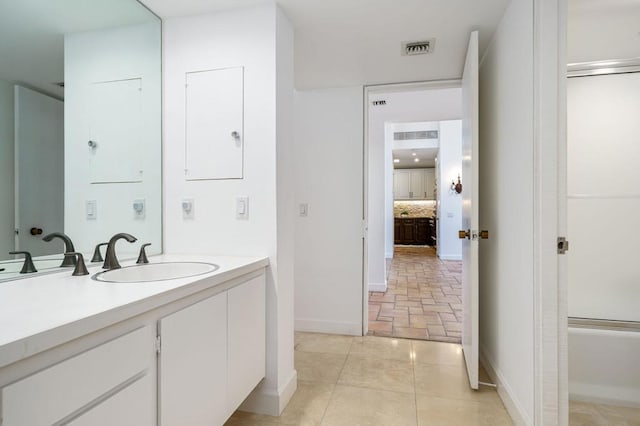 bathroom with vanity and combined bath / shower with glass door