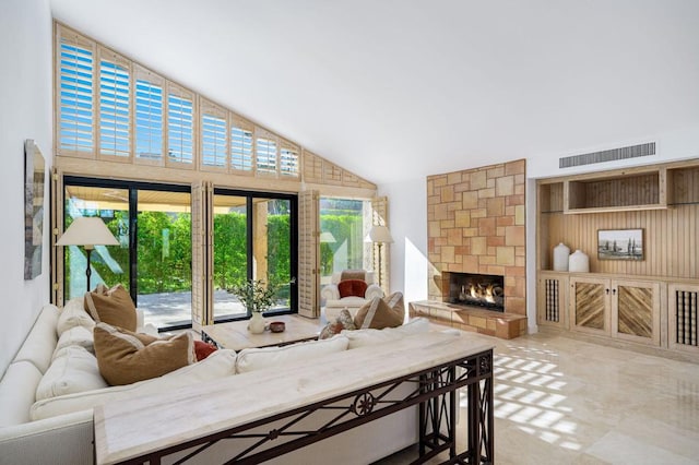 living room featuring high vaulted ceiling and a fireplace