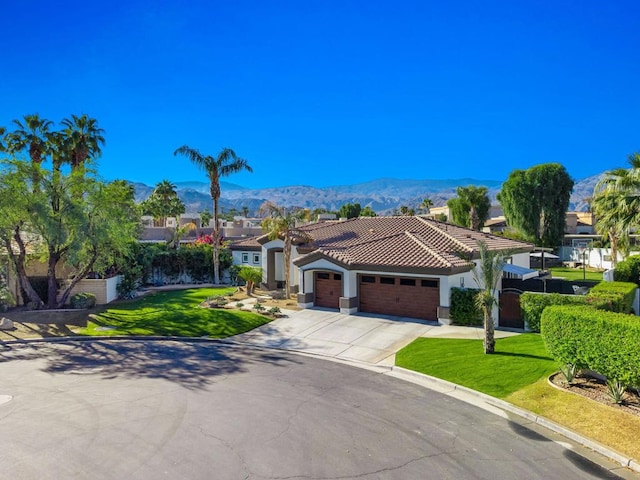 mediterranean / spanish home with a mountain view, a front lawn, and a garage