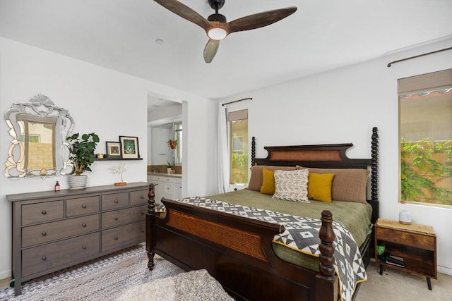 carpeted bedroom with ceiling fan, connected bathroom, and multiple windows