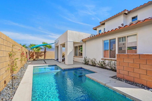 back of house with a fenced in pool