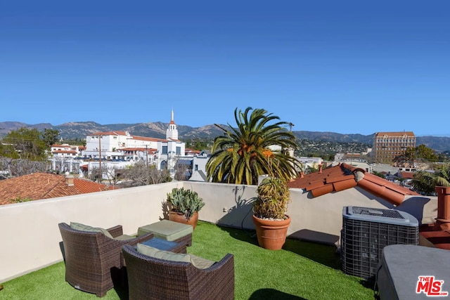 view of patio / terrace with a mountain view, a balcony, and central AC