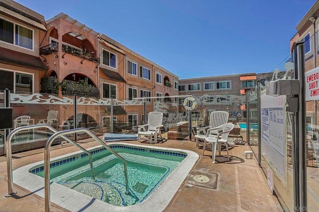 view of pool with a hot tub and a patio area