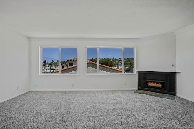 unfurnished living room with a wealth of natural light, ornamental molding, carpet, and a tile fireplace