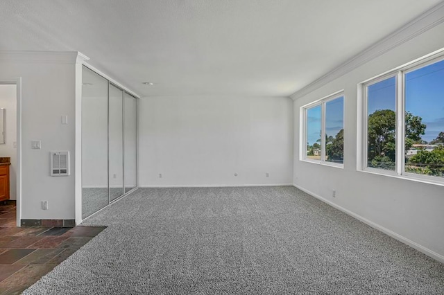 empty room with crown molding and dark colored carpet