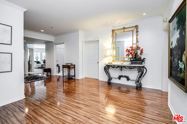 entrance foyer featuring ornamental molding and hardwood / wood-style flooring