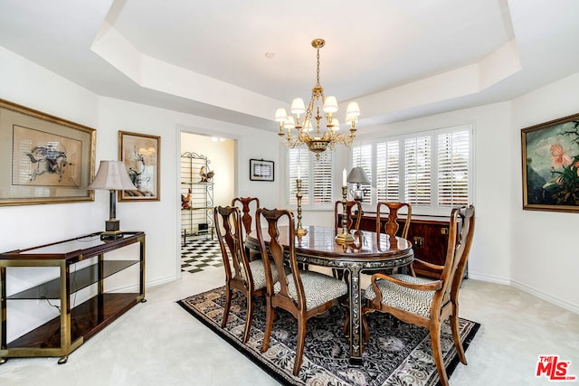 carpeted dining area featuring an inviting chandelier and a raised ceiling