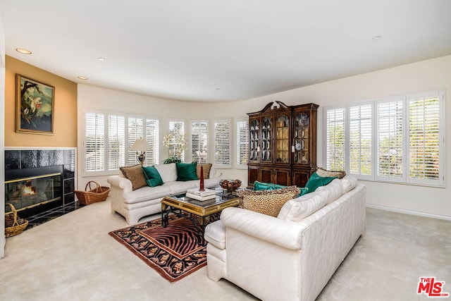 living room featuring a tiled fireplace, light carpet, and plenty of natural light